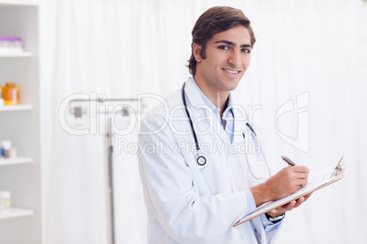 Side view of smiling doctor taking notes