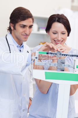 Male doctor adjusting scale for his patient