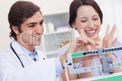 Male doctor adjusting scale for excited patient