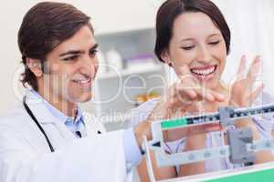 Male doctor adjusting scale for excited patient