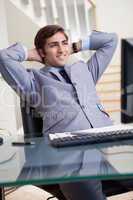 Smiling businessman leaning back in his office