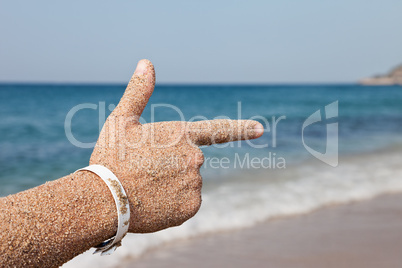 Hand forefinger pointing sea beach