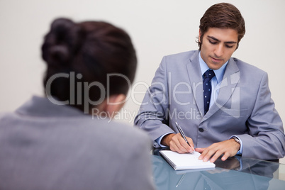 Businessman in meeting taking notes