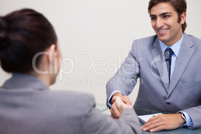 Business partners sitting at a table shaking hands