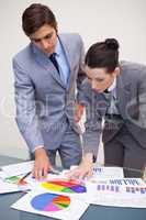 Business partners looking at statistics together