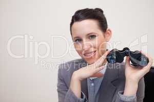Smiling businesswoman with binoculars