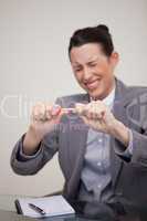 Angry businesswoman trying to break pencil