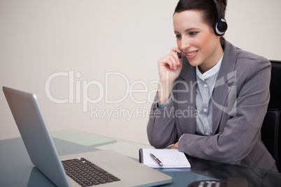 Businesswoman with headset on her laptop