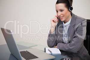 Businesswoman with headset on her laptop
