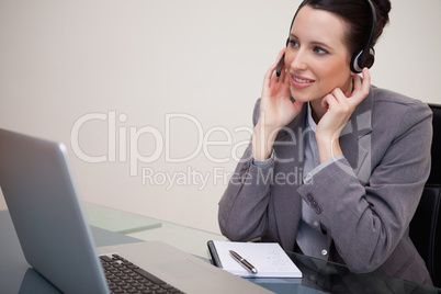 Businesswoman with headset sitting at her desk