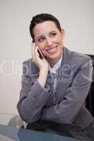 Businesswoman on the cellphone behind her desk