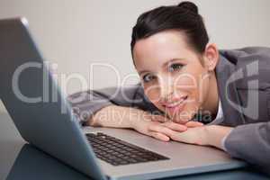 Happy businesswoman leaning against her laptop