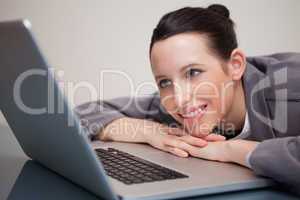 Smiling businesswoman leaning against her laptop