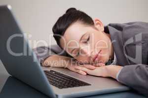 Businesswoman taking a nap on her laptop