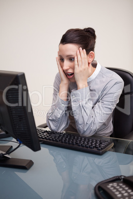 Businesswoman getting surprised by computer