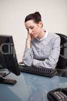 Businesswoman sitting bored at her desk