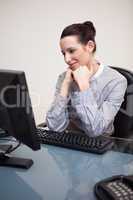 Happy smiling businesswoman sitting at her desk