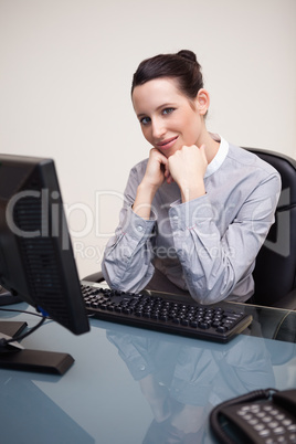 Smiling businesswoman waiting patiently at her computer