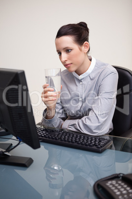 Businesswoman at her desk with a glass of water