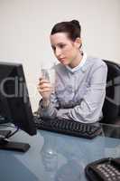 Businesswoman at her desk with a glass of water