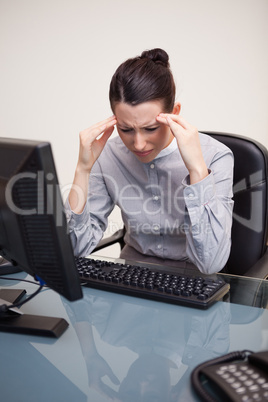 Businesswoman having a headache at her desk