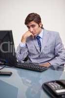 Businessman sitting bored at his workplace