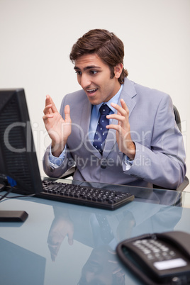 Businessman getting confused by his computer