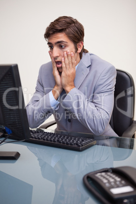 Businessman getting negative surprised by his computer