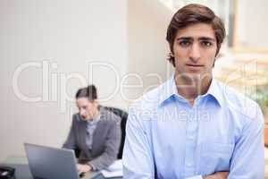 Businessman with colleague on her notebook behind him