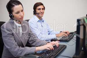 Side view of call center agents working in their office