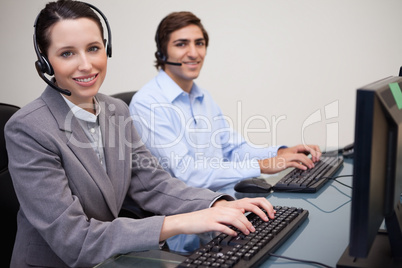 Side view of smiling call center agents at work