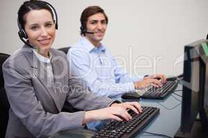 Side view of smiling call center agents at work