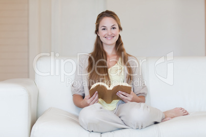 Woman reading a book on the couch