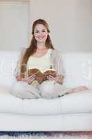 Woman enjoys reading a book on her couch