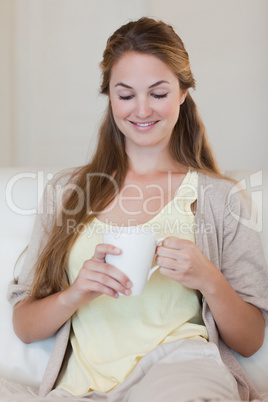 Woman enjoys having a coffee on her couch