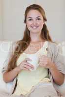 Woman having coffee on her sofa