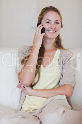 Smiling woman listening to caller on her cellphone