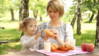 mother and daughter family breakfast in nature