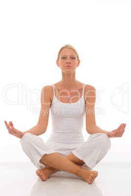 a young caucasian woman dressed in white sitting cross-legged do