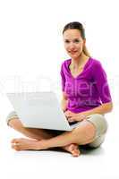 Young woman sitting on the floor with laptop on white background