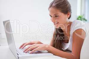 Side view of smiling woman on her laptop