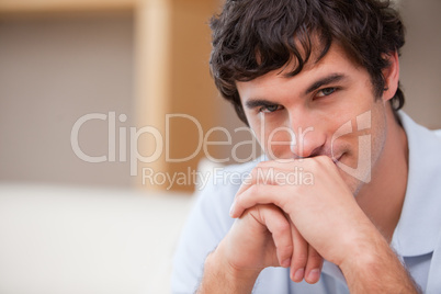 Man with hands folded in the living room