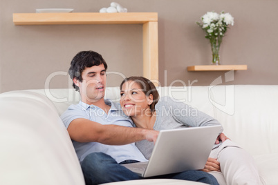 Couple with their laptop on the sofa