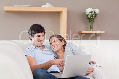 Couple with their notebook on the sofa