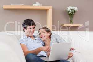 Couple with their notebook on the sofa