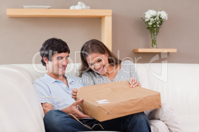 Couple on the sofa opening parcel