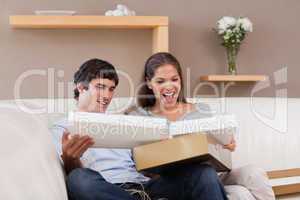 Couple on the couch opening parcel