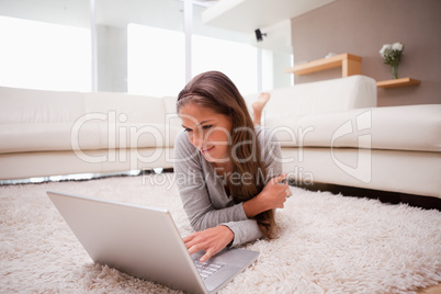 Woman lying with laptop on the floor