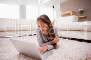 Woman lying with laptop on the floor