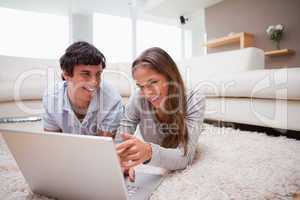 Couple with laptop on the carpet